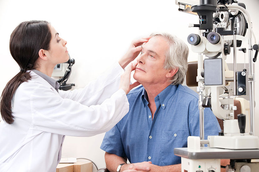 Eye doctor examining an old man