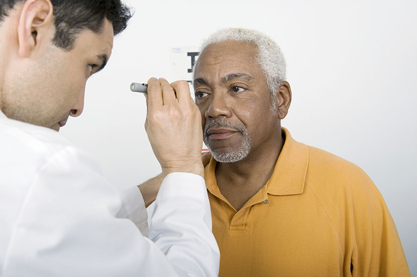 Eye doctor examining an old man