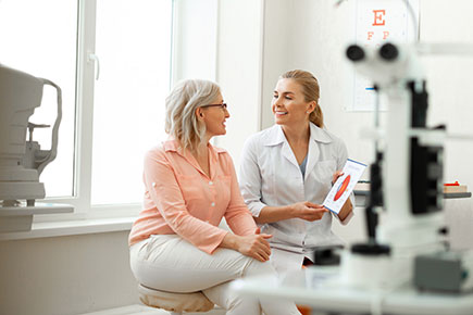 Eye doctor talking to old woman