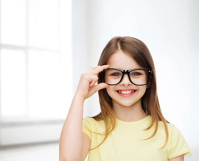 Young girl in yellow shirt with eyeglasses